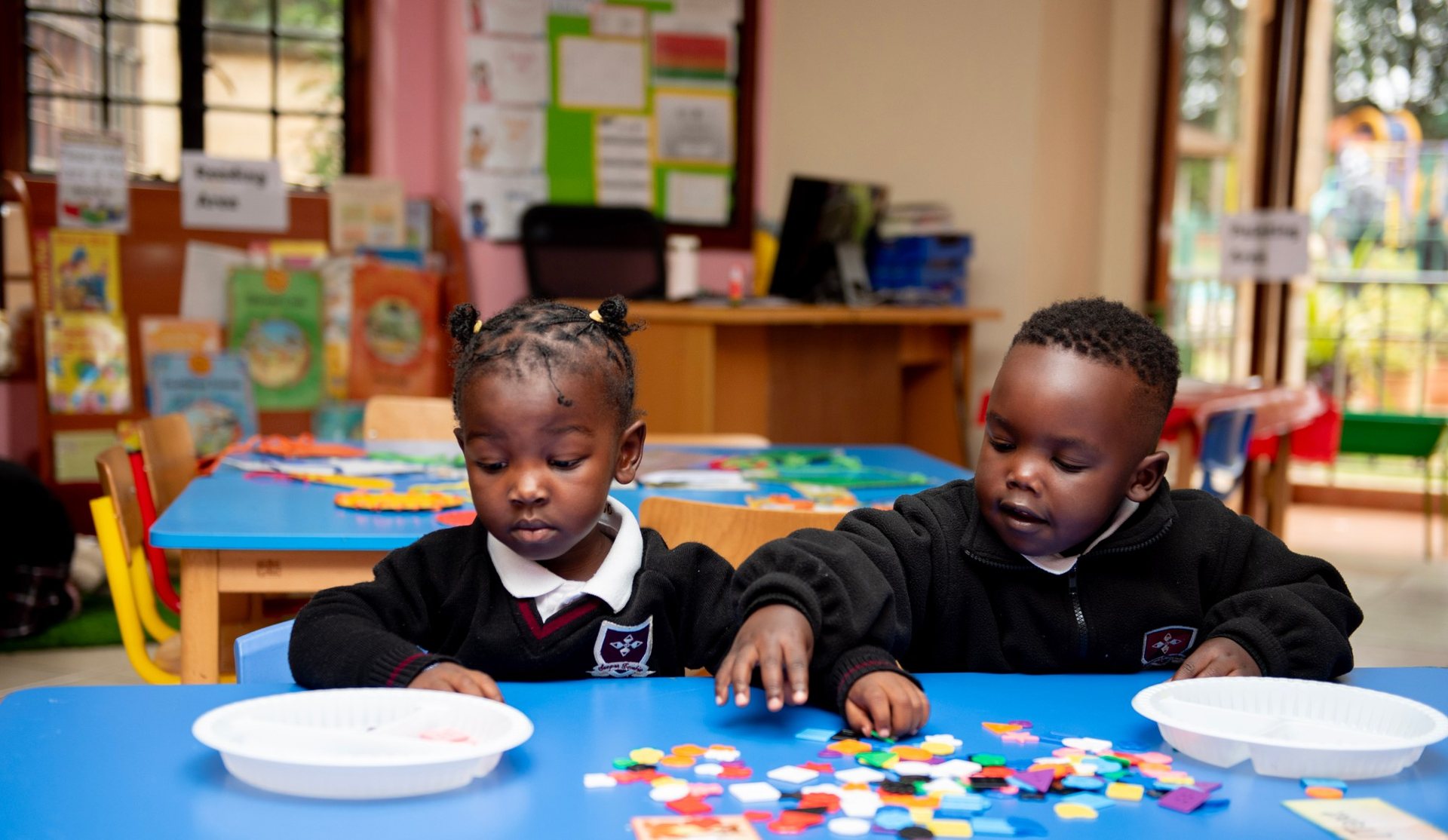 Kindergarten pupils sorting coloured shapes in class at St. Christopher's International School